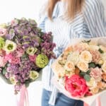 two beautiful bouquets of mixed flowers in womans hands. the work of the florist at a flower shop. delicate pastel color. fresh cut flower.